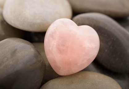 Rose quartz heart on pebbles