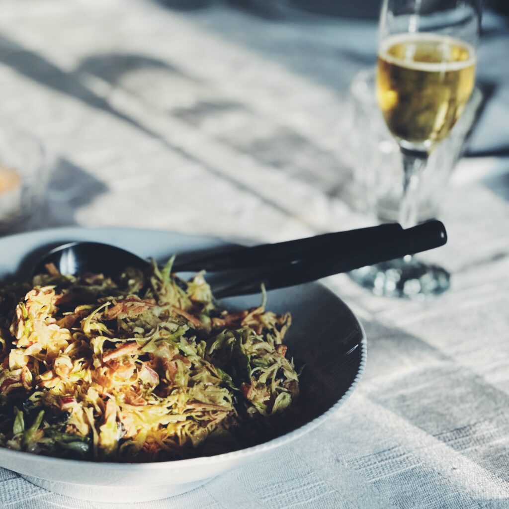 Fad med kålslaw og champagneglas i baggrunden