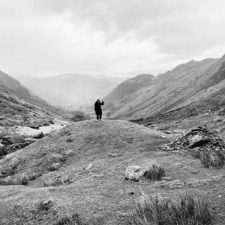 Person i bjerglandskab, sort-hvidt billede